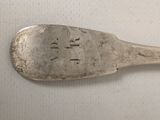 a silver spoon with writing on it sitting on a table