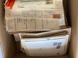 une boîte en carton remplie de courrier et d'un paquet de timbres