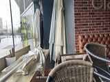 tables and chairs in front of a window with a view of a city