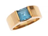 Gros plan sur une bague en or ornée d'une topaze bleue