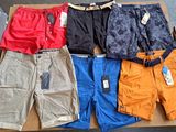 Plusieurs paires de shorts pour hommes sont posées sur une boîte en carton