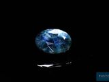 a close up of a blue and white stone on a black surface