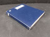 a blue book sitting on top of a table next to a black table
