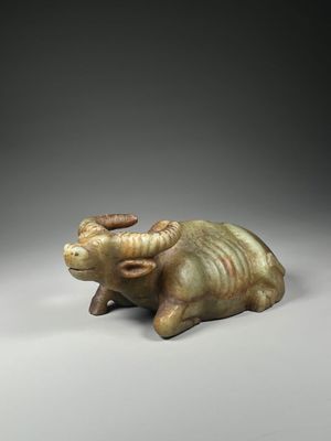 a close up of a statue of a bull on a gray surface