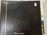 a black book sitting on top of a table next to a white sheet
