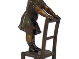 statue en bronze représentant une petite fille assise sur une chaise, les mains posées sur le dossier de celle-ci