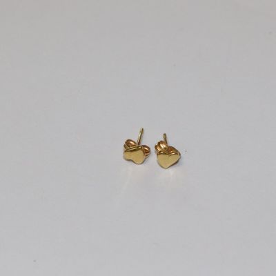une paire de boucles d'oreilles en or en forme de cœur posées sur un fond blanc