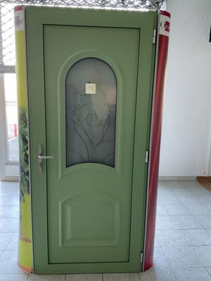 une porte verte ornée d'une image, au milieu d'une pièce