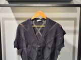 La chemise est suspendue à un cintre devant une porte.