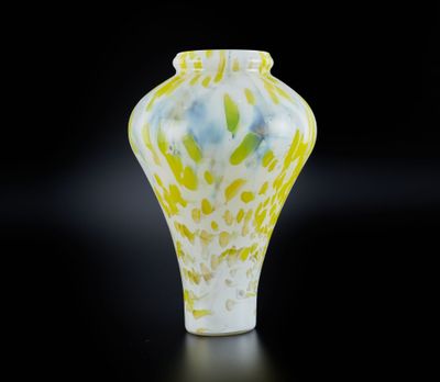 vase en verre jaune et blanc sur fond noir, avec reflet