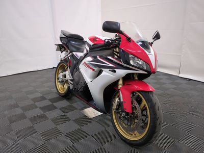 a picture of a red and white motorcycle parked on a black and white checkered floor