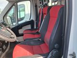 the interior of a van with red and black seats and a steering wheel