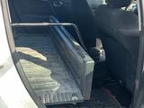 a small white car with its door open in the parking lot