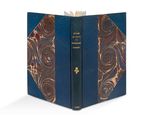 un livre ouvert dont la couverture est bleue et ornée de motifs dorés