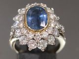 gros plan d'une bague en saphir bleu et diamant sur une surface noire