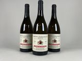 trois bouteilles de vin posées sur une table l'une à côté de l'autre