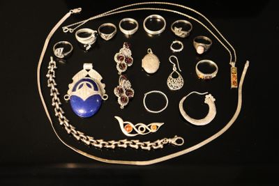 many different types of jewelry displayed on a black surface