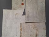 plusieurs vieux morceaux de papier avec des inscriptions, posés sur une table