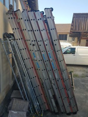 a pile of ladders leaning against a building