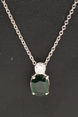 an emerald and diamond pendant on a silver chain