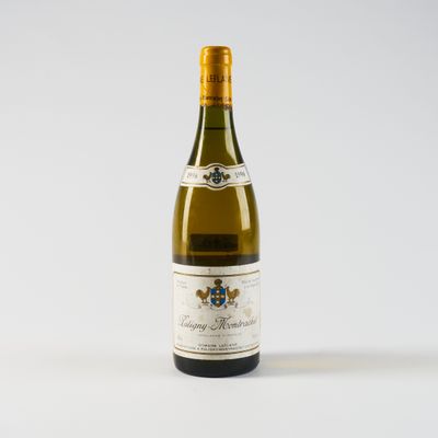une bouteille de vin blanc posée sur une table blanche