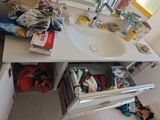 a bathroom sink with a lot of clutter in it