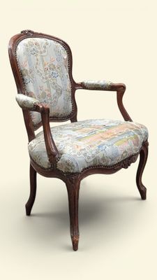 une chaise dont le dossier est recouvert d'un tissu à motifs floraux et dont la structure est en bois