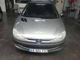 une voiture argentée garée dans un garage, avec d'autres voitures en arrière-plan