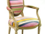 une chaise rembourrée dont l'assise est recouverte d'un tissu à rayures multicolores