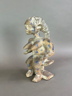 une figurine représentant un homme assis sur un rocher