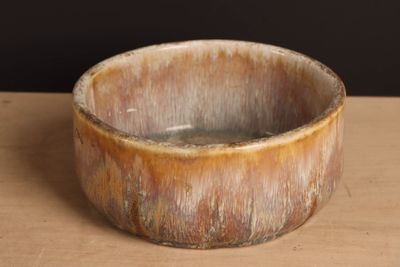 un bol marron posé sur une table en bois