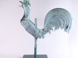 statue of a rooster on a green base on a white background