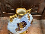 a blue and gold vase sitting on a wooden table