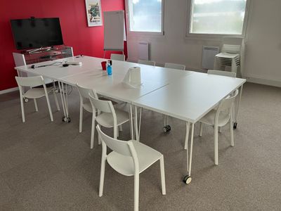 a white table and chairs in a room with a red wall