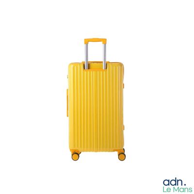 the yellow suitcase is sitting on wheels on a white surface