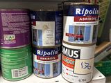 many cans of paint on a shelf in a store