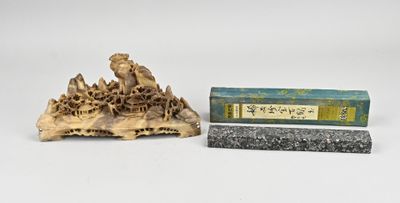 une image représentant une petite statue d'un homme assis sur un rocher, à côté d'une boîte d'encens