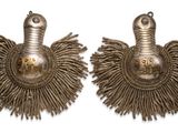 pair of silver earrings with feathers on them on a white background