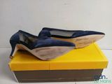 blue high heel shoes on a yellow box on a white surface