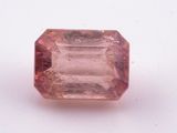 a close up of a pink sapphire stone on a white surface