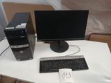 un ordinateur de bureau posé sur un bureau, à côté d'un clavier et d'un écran