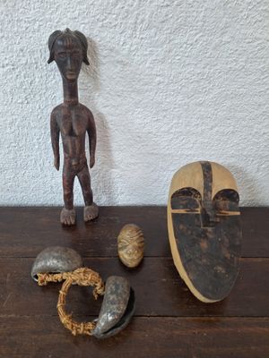 figurine en bois représentant un homme debout à côté d'autres objets posés sur une table en bois