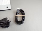 a cable and a charger sitting on a table next to a computer