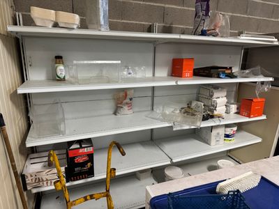 a blue sink in the middle of a room with shelves