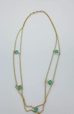 un collier en or orné de perles de verre vertes et d'une chaîne en or
