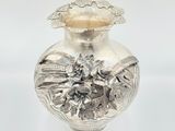 a silver vase sitting on a white surface with a white background