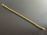 gros plan d'un bracelet en or sur une surface noire