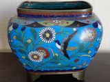 a blue vase with a bird on it sitting on a table