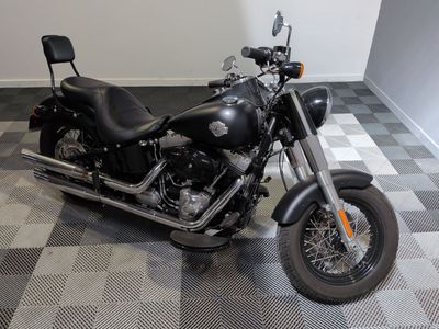 une moto noire garée sur un sol à damier