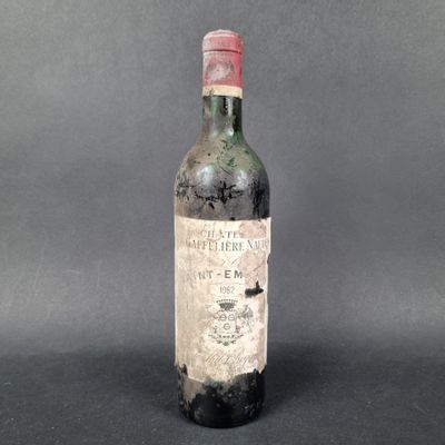 an old bottle of wine sitting on top of a table